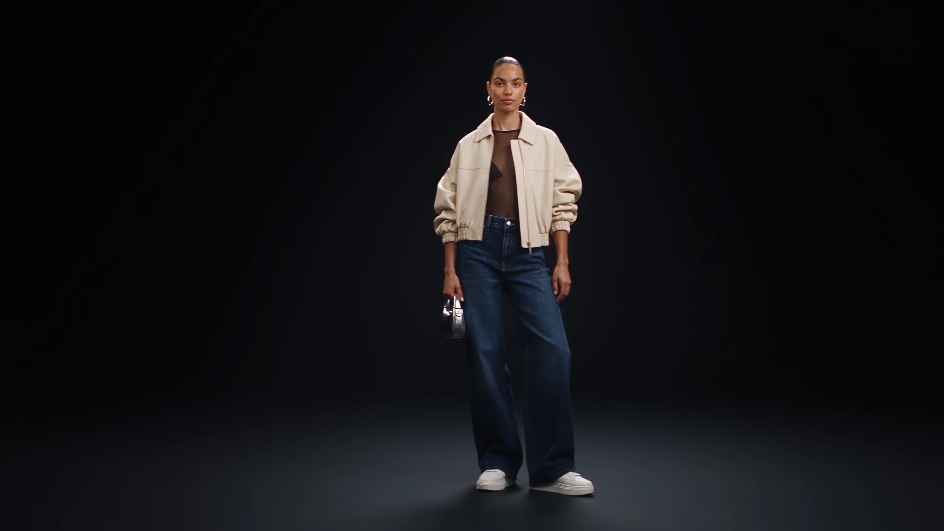 Curiella fashion concept: a model in a neutral jacket and dark denim